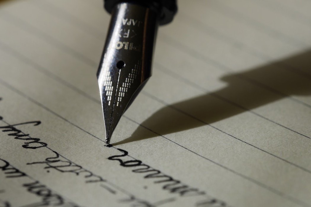 A writer editing text on a laptop at a desk